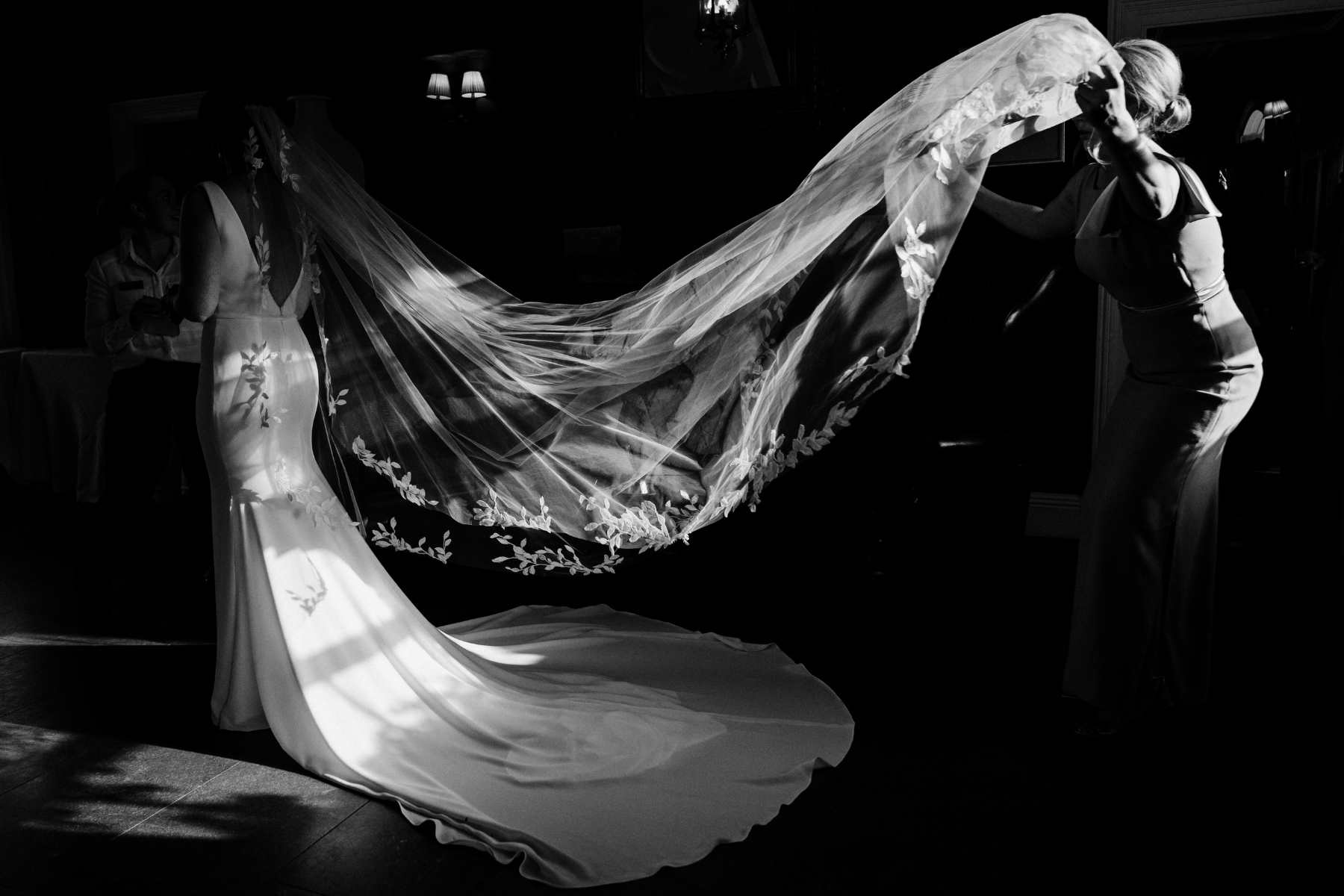 bridesmaid fixing bridal veil on bride